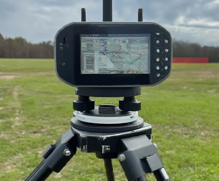 Professional GPS receiver mounted on a tripod in an open field width=